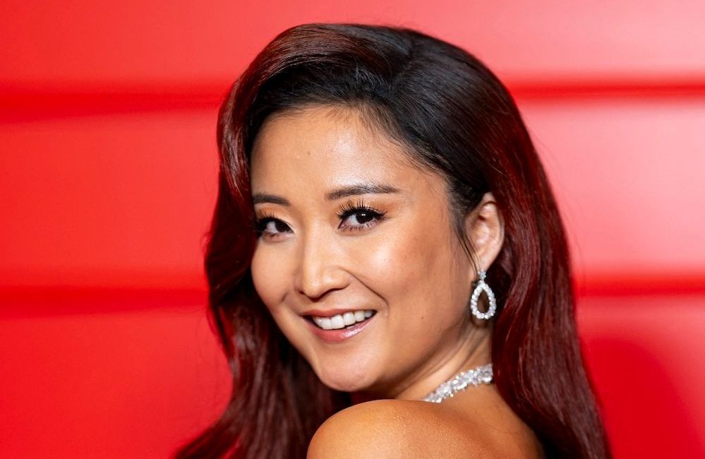 Coloration « Cherry Cola » et racines noires : Ashley Park mêle deux grandes tendances capillaires et signe un look glamour