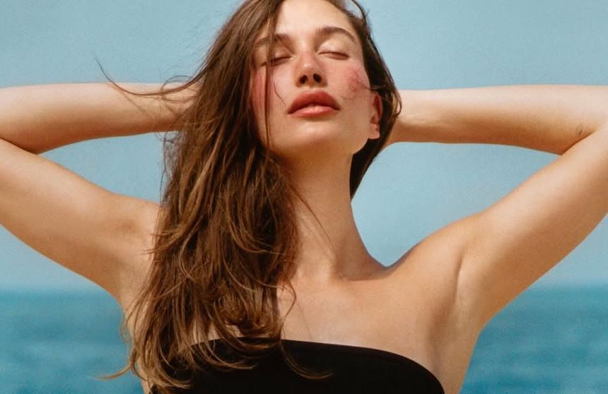 Et si le nouveau geste de l’été tenait à la taille ? Hailey Bieber imagine un bijou de corps pour transporter son baume à lèvres